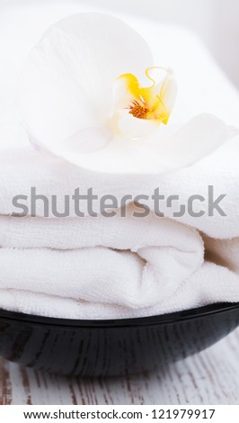 White Orchid flower and white towel on a wood background