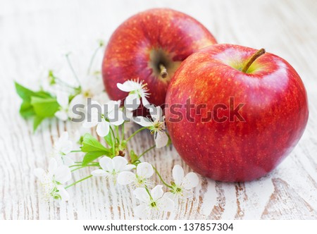 Two apples and spring blossom on a wooden background
