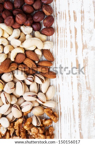 Mixed nuts on a old wooden background - Nuts left side frame
