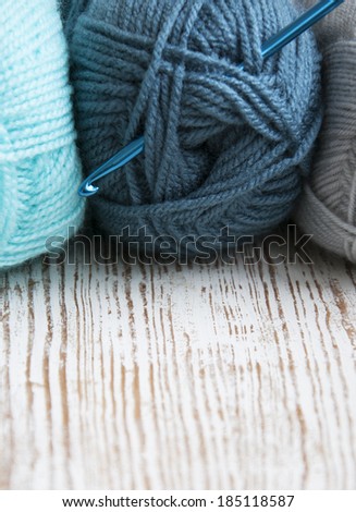 Crochet hook and knitting yarns on a white background