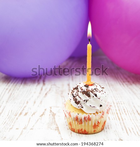 Tasty birthday cupcake with candle on wooden table