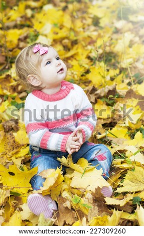 little baby girl playing with  autumn leaves