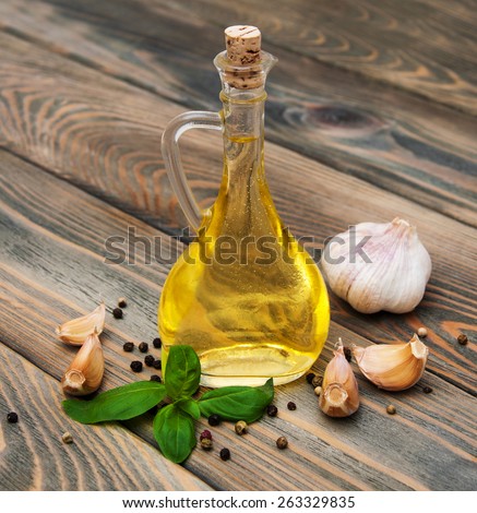olive oil with fresh basil and garlic on a old wooden background