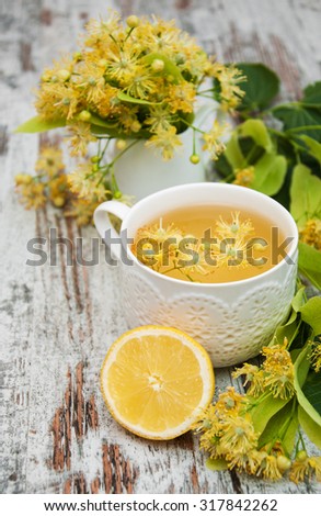 cup of herbal tea with linden flowers on a old wooden background