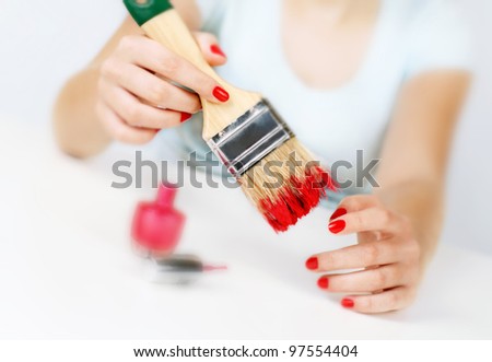 Girl paints nails with the big brush. Women\'s quirks. Humor.