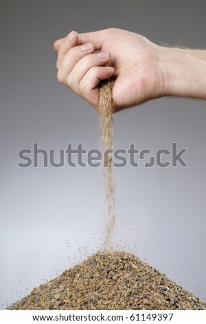 Man adding sand in a heap with his hand