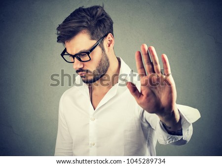 Annoyed sad man giving talk to hand gesture isolated on gray background. Negative emotion face expression feeling body language Сток-фото © 