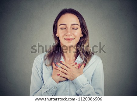 Woman with eyes closed keeps hands on chest near heart, shows kindness, expresses sincere emotions, being kind hearted. Body language feelings concept Foto stock © 