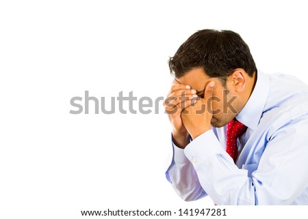 Closeup side view profile portrait, sad, bothered, stressed young man covering face with hands really depressed about something, isolated white background. Negative emotion facial expression feeling