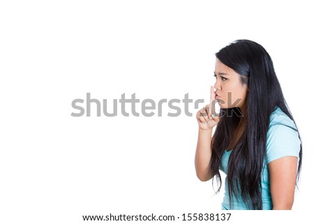 Closeup side view portrait of woman placing finger on lips as if to say, \