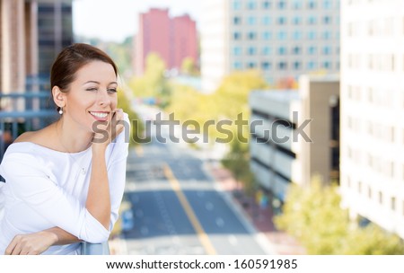 Closeup portrait of beautiful, happy, relaxed woman enjoying a weekend on sunny day, on balcony of her apartment isolated on city background. Urban life style of businesswoman, corporate professional