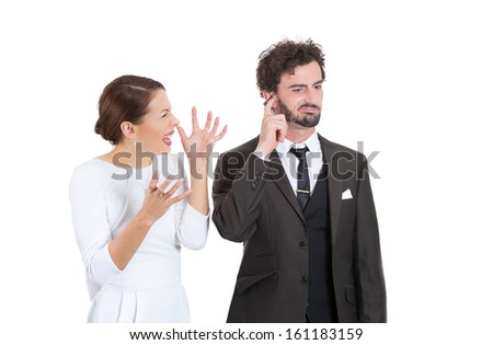 Portrait of stressed young couple going through hard times in their relationship, isolated on a white background . Wife, girlfriend trying to explain something to man, he is annoyed and closes ears.