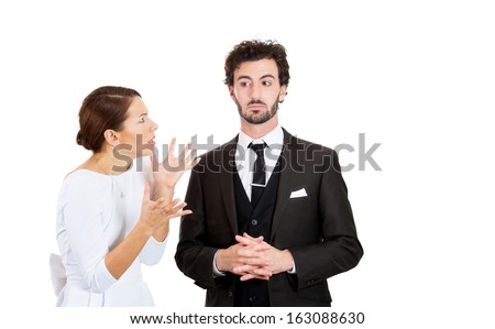 Portrait of stressed young couple going through hard times in relationship, isolated on white background. Upset, angry, mad wife, girlfriend trying to prove her point to clueless, annoyed man, husband