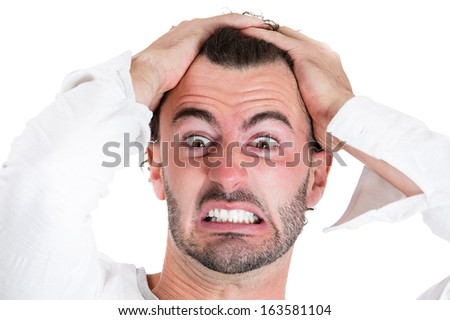 Closeup portrait of angry, unhappy, frustrated, stressed young man, pulling his hair out, isolated on white background. Negative human emotions and facial expressions. Conflict situation, resolution