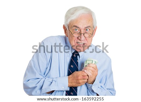 Closeup portrait of greedy senior executive, CEO, boss, old corporate employee, mature man, holding dollar banknotes tightly, isolated on white background. Negative human emotion facial expression