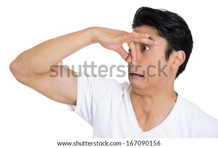 Closeup portrait of young man, disgust on his face, pinches his nose looks at you, something stinks, very bad smell, situation, isolated on white background. Negative emotion facial expression feeling