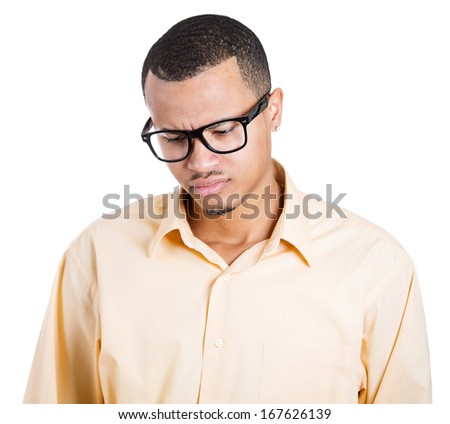 Closeup portrait of handsome, young man, sad student with black glasses, looking down, isolated on white background. Human face expression, emotion, feeling, attitude, perception, reaction to conflict