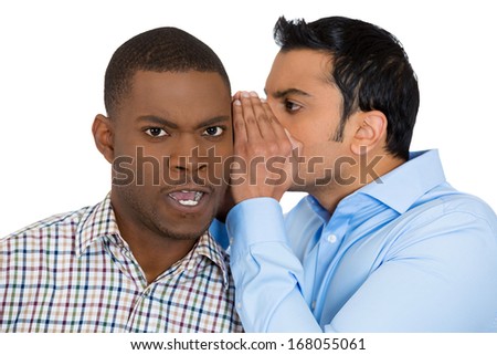 Closeup portrait of guy whispering into man\'s ear telling him something secret and disturbing. Shocked surprised disgusted annoyed mad response. Negative human emotions facial expression feelings