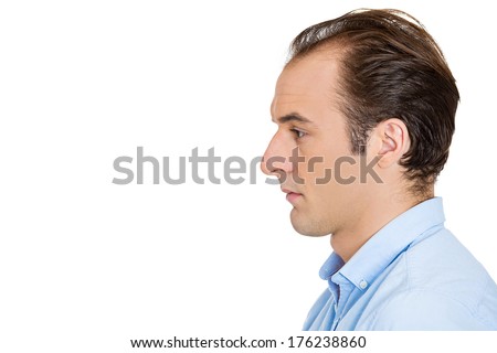 Closeup side view profile head shot portrait of sad bothered stressed serious young man depressed about something or someone, isolated white background. Negative emotion facial expression feeling