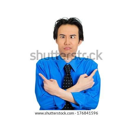 Closeup portrait of confused young man pointing in two different directions, not sure which way to go in life, isolated on white background. Negative emotion, facial expression feelings, body language