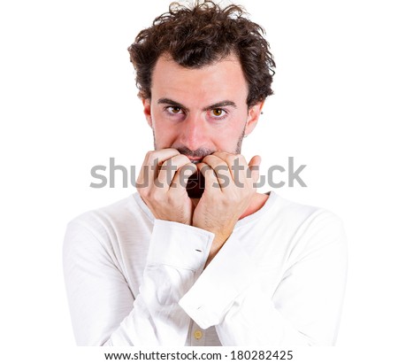 Closeup portrait of nerdy, shy, confused young guy, scared, shocked man biting his nails looking staring at you with craving for something isolated on white background. Human emotion facial expression