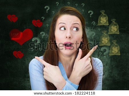Closeup portrait confused young woman pointing in two different directions, not sure which way to go in life, isolated green background with dollar signs, red hearts. Emotion facial expression feeling