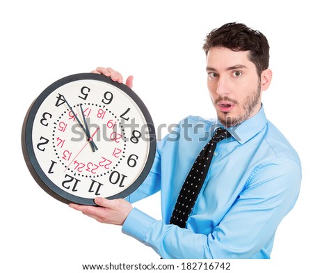 Closeup portrait business man, worker, guy holding clock looking anxiously, pressured by lack, running out of time isolated white background. Human face expression, emotion, reaction, corporate life
