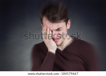 Closeup portrait, stressed man, overwhelmed student, upset mad employee having headache, pressured by lack of time, boss, project, family life, isolated smeared gray black background.