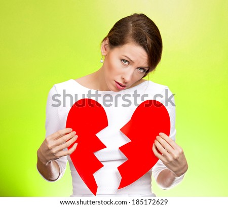 Closeup portrait young, troubled, sad, confused woman, holding broken heart in hands, about to cry, isolated green background. Negative human emotions, facial expression, feelings, attitude, reaction