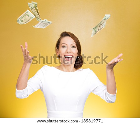 Closeup portrait super excited, laughing young woman who just won lots of money, trying to catch, throw dollar bills in air, isolated yellow background. Positive emotion, facial expression, feelings.