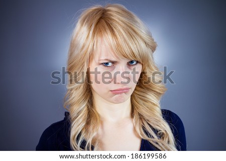 Closeup portrait skeptical, young woman looking suspicious, disgust face, mixed with disapproval, isolated dark blue background. Negative human emotion, facial expression, feeling, attitude, reaction