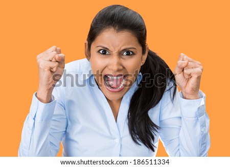 Closeup portrait, bitter displeased pissed, angry, cranky, grumpy, woman teeth, fists in air, screaming, shouting, yelling isolated orange background. Negative human emotion facial expression feeling