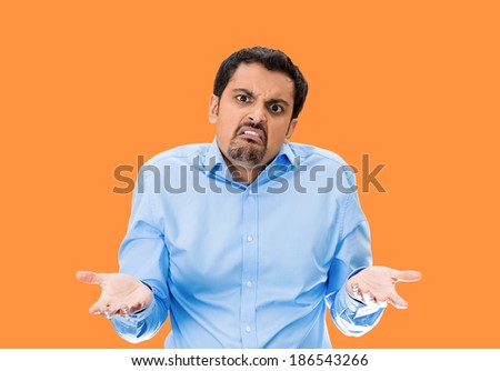 Closeup portrait, angry, upset young man, arms out asking why whats the problem who cares so what, I dont know. Isolated orange background. Negative human emotion facial expression feelings