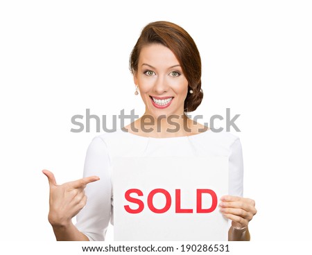 Closeup portrait, super happy excited successful young business woman holding, pointing to red sold sign, isolated white background. Positive emotion feeling. Financial reward