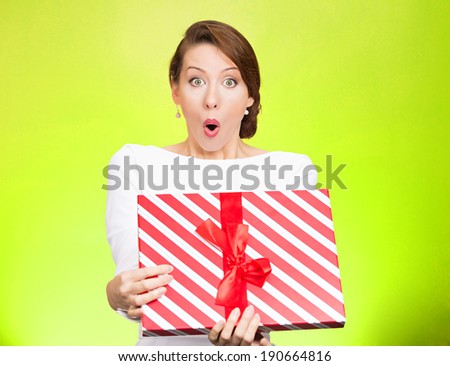 Closeup portrait happy super excited, surprised young woman, received unexpected gift box,opened eyes, mouth isolated green background. Positive emotion, facial expression, feeling, attitude, reaction