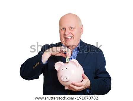 Closeup portrait, senior mature, happy, successful elderly man holding piggy bank making money cash deposit, contribution isolated white background. Clever financial decision, saving, tax free account