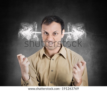 Closeup portrait angry young man, blowing steam coming out of ears, about to have nervous atomic breakdown, isolated black background. Negative human emotions, facial expressions, feelings, attitude