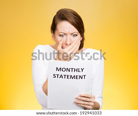 Closeup portrait shocked, funny looking business woman, disgusted at monthly statement, can\'t believe her eyes, isolated yellow background. Negative human emotion, facial expression, feeling. Bad news