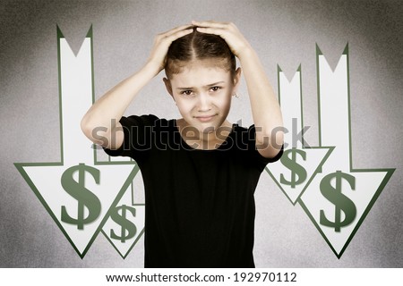 Closeup portrait scared, funny looking little girl, hands on head, stressed, market, dollar going down, isolated dark, grey background with arrows. Facial expressions, emotions. Future economy worries
