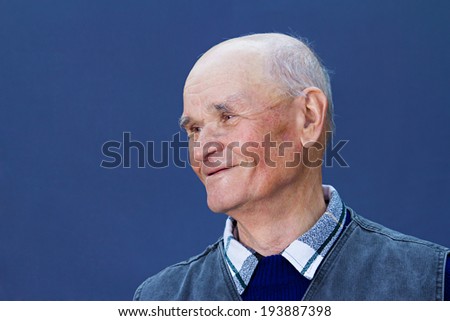 Closeup portrait, headshot happy, smiling mature, old man, grandpa isolated blue background. Positive human emotions, facial expressions, reaction, life perception, attitude