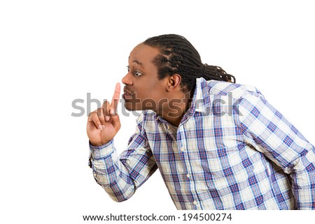 Closeup portrait young serious man placing finger on lips to say, shh, be quiet, silence, isolated white background.