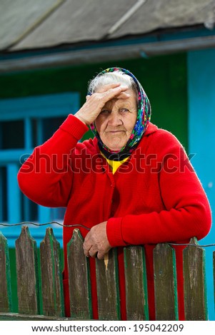 Closeup portrait sad, senior, elderly woman, grey hair on porch of her house, thoughtful, looking at you as if she is waiting for someone. Human emotions, facial expressions, life perception, reaction