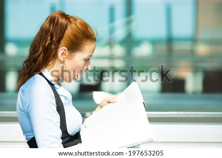 Closeup side view portrait business woman, reading latest news in magazine, surprised, unexpected events on stock market, isolated background corporate office. Human facial expression emotion reaction