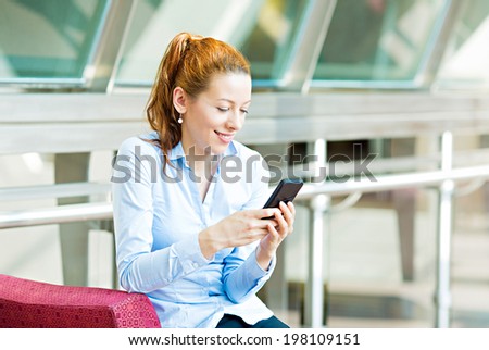 Closeup portrait, happy, cheerful, girl, excited by what she sees on cell phone, isolated background corporate office. Facial expression, reaction. Business woman sending text message from her mobile
