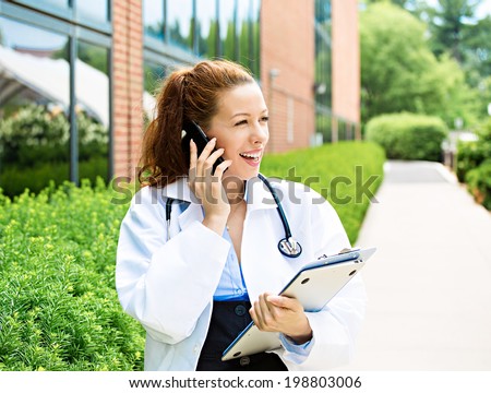 Closeup portrait, young smiling confident female doctor, healthcare professional talking on phone, giving consultation isolated background hospital campus. Patient visit health care. Positive emotions