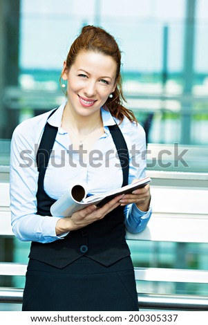 Closeup portrait business woman, editor reading latest news in magazine, smiling happy, great news article, ideas isolated background corporate office windows. Positive human facial expression emotion