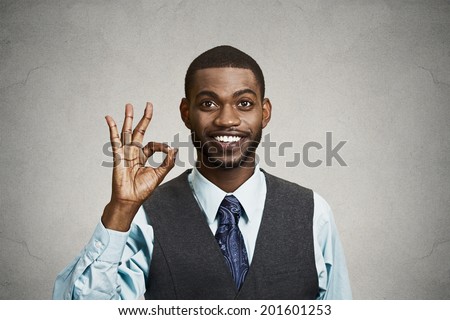 Closeup portrait young handsome, happy, smiling, excited man, corporate employee, worker giving OK sign with fingers, isolated black grey background. Positive human emotion facial expressions, symbol