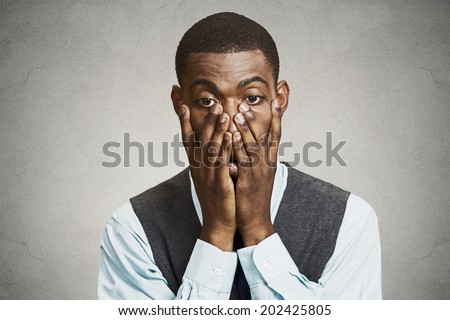 Closeup portrait, headshot young tired, fatigued business man worried, stressed, dragging face down with hands, isolated black, grey background. Negative human emotions, facial expressions, feelings