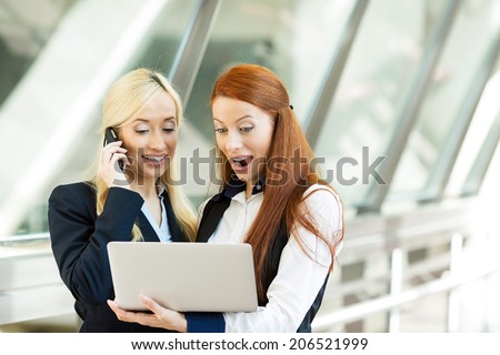 Closeup portrait happy surprised business women, company partners receiving news on computer internet, talking on smart phone celebrating success isolated background corporate office. Positive emotion