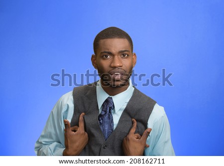 Closeup portrait angry, unhappy annoyed, rude young executive man, getting mad asking question you talking to, mean me? Isolated blue background. Negative emotion facial expression feeling attitude